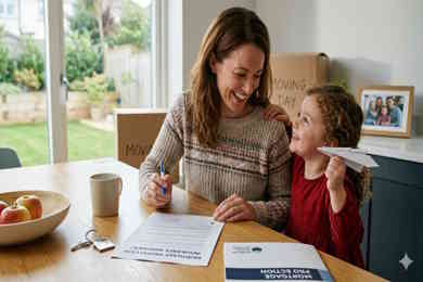 Insurance Homeowners - mother and daughter happy, mother is signing house insurance documents