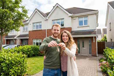 Mortgage services - couple in front of new house with keys. Mortgage approved by JC Mortgages